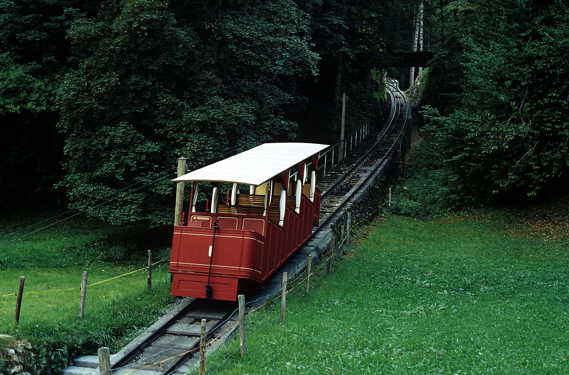 The red 1899 funicular car climbing through the forest